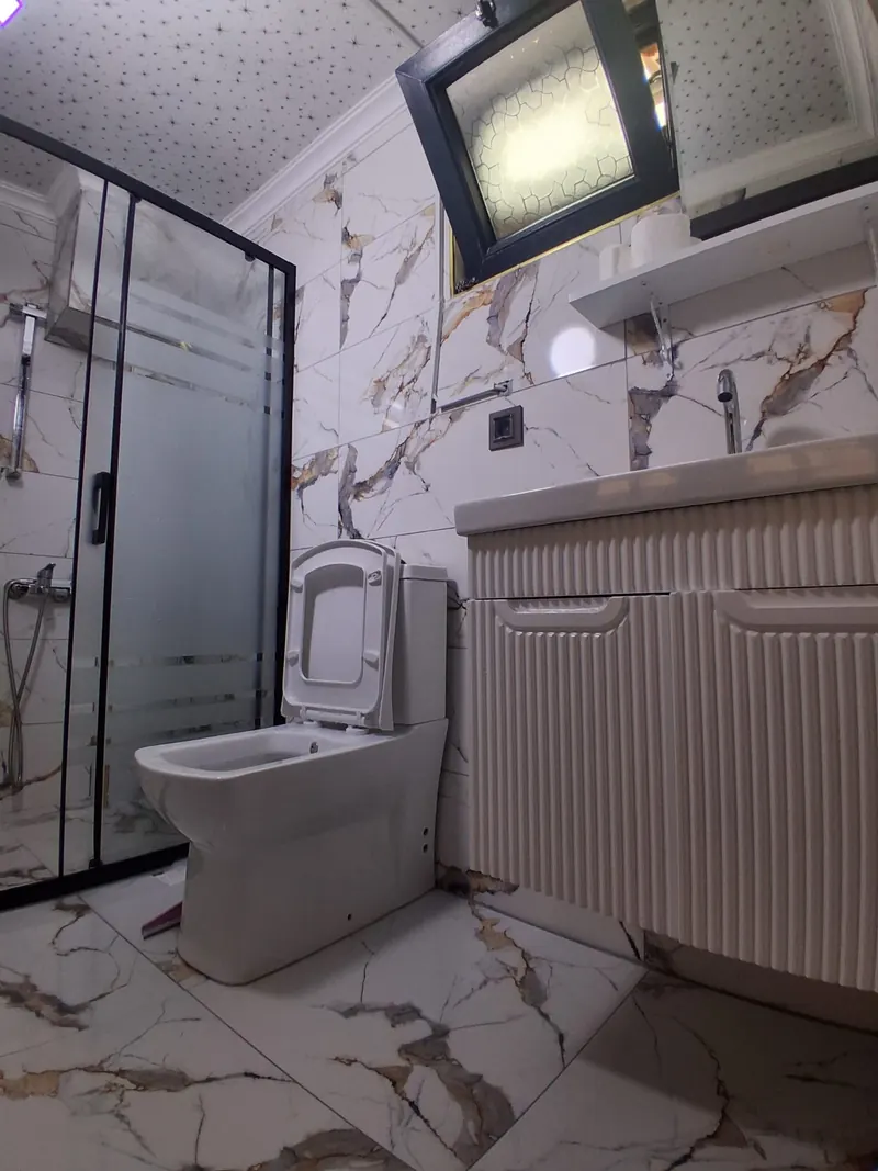 Duşakabinli, mermer desenli özel banyo